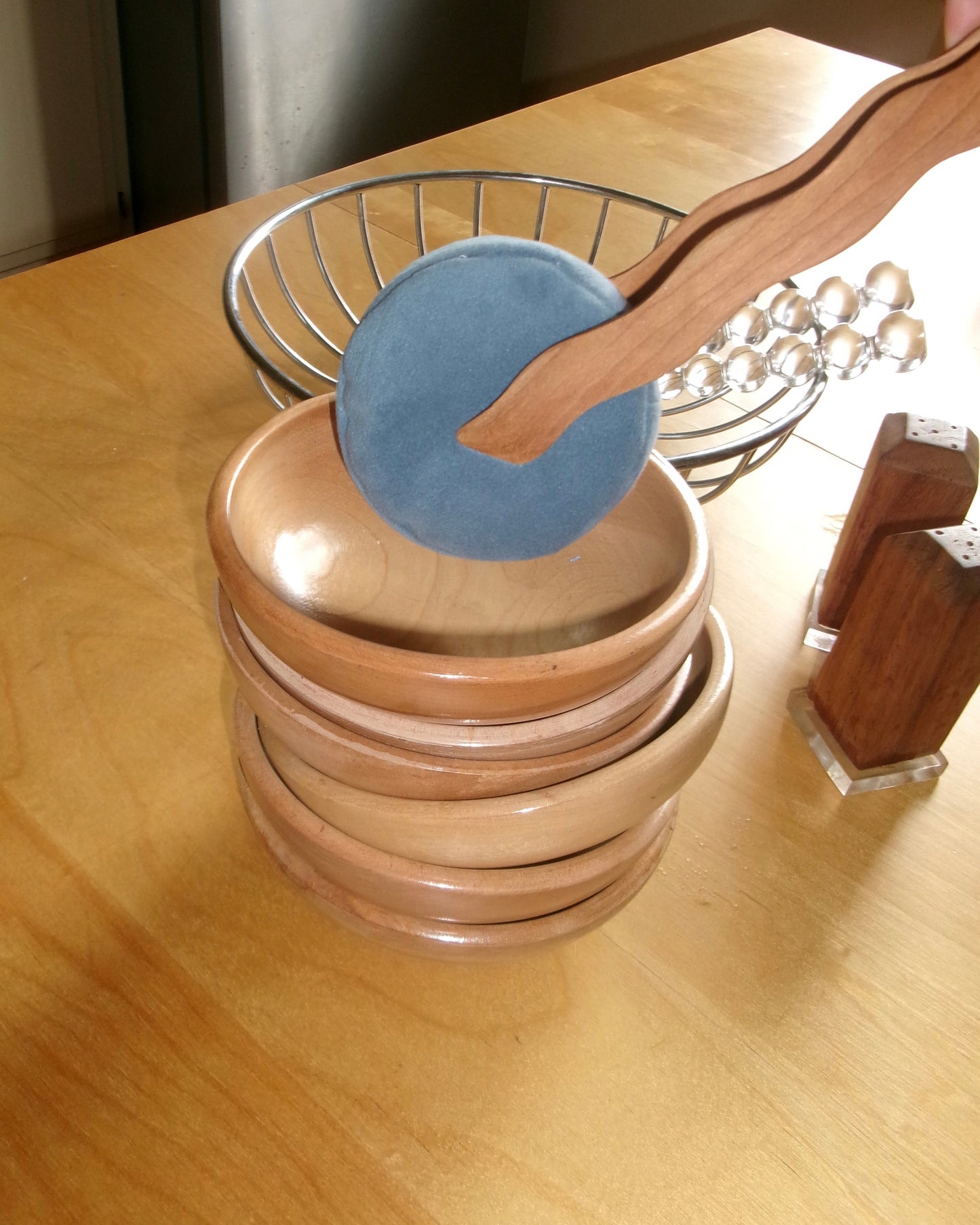 wavy wooden tongs picking up mini dot pillow and "serving" it into wooden bowls.
