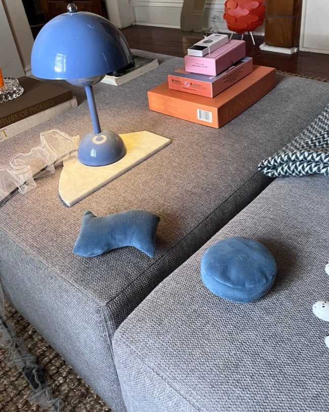 Mini blue wavy and dot pillows on a styled modern ottoman