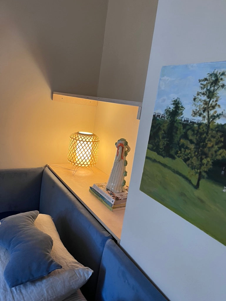 Blue wavy pillow displayed on a bed with a matching headboard.